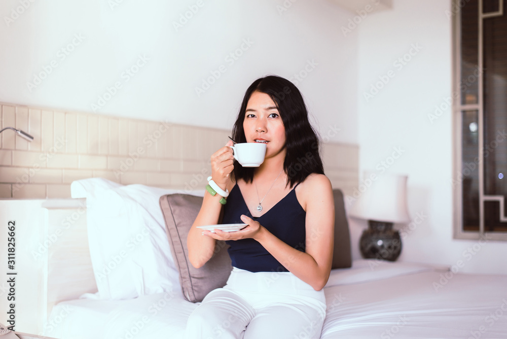 Beautiful asian woman drinking hot coffee in bedroom,Relax time,Happy and smiling,Healthy and lifestyle concept Beautiful asian woman drinking hot coffee in bedroom,Relax time,Happy and smiling,Healthy and lifestyle concept