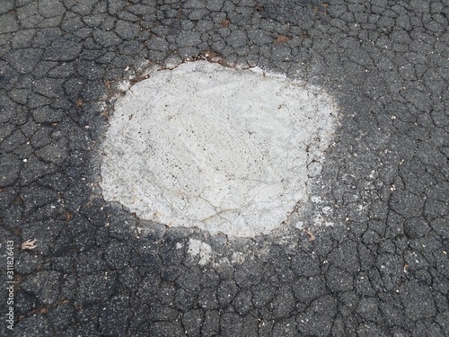 broken or damaged asphalt repaired with white filling © Justin