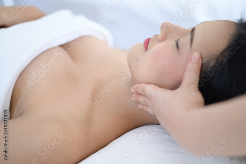 A beautiful woman slept with eyes and massage the face and head at the spa.
