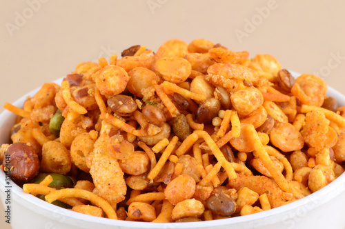 Indian Snacks : Mixture (roasted nuts with salt pepper masala, pulses, channa masala dal green peas) in blue bowl in photo