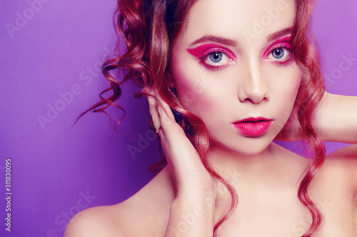 Beautiful young girl with purple make-up, on a purple background. Ideal makeup, eyebrows. Fashion girl photo. Pink makeup and background.