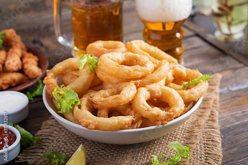 Onion rings in batter with sauce and cheese sticks. Beer snacks. Copy space