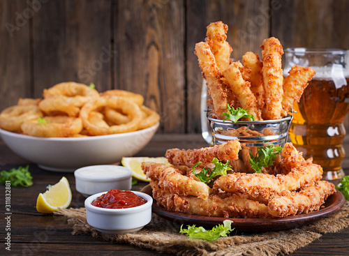 Foto Cheese sticks  and onion rings in batter with sauce