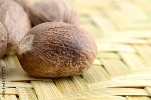 Nutmeg in bamboo basket isolated on white background photo