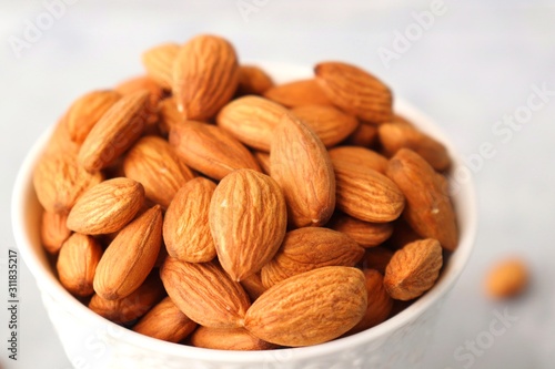 Almonds in white bowl on table. Almond Food or ingredient concept with copy space