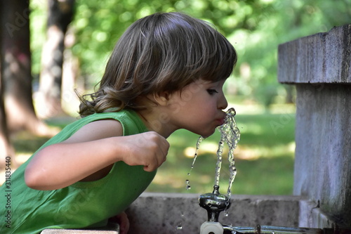 Konstfotografi child drinks water from a fountain