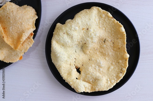 Indian crunchy fried snack papad or Papadam made of rice floor served in a plate. Also known as khichiya Papad. photo