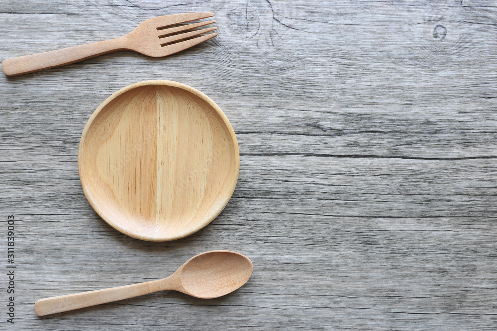 Wooden bowl with spoon and fork on wooden background Wooden bowl with spoon and fork on wooden background
