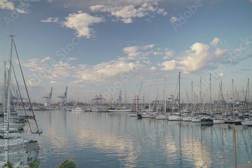 Luxury power boats in the Royal Marina in Valencia Spain, some moored,others sail on the sea. The city of Calpe in Spain, Valencia, Europe, in the cloudy evening 