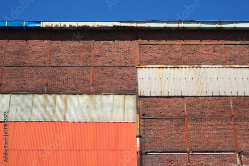 Brick and colorful metal plate wall texture background.
