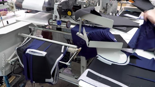 Computer manufacturer machine for sewing pockets to the product at the sewing factory. Modern technology replaces manual work and speeds up production. 4k footage.