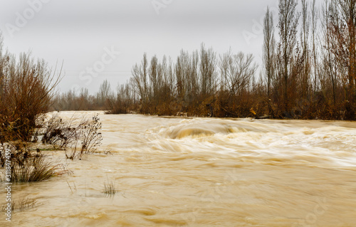 Tableau sur toile Paisaje invernal de la crecida del Río Bernesga con niebla de fondo