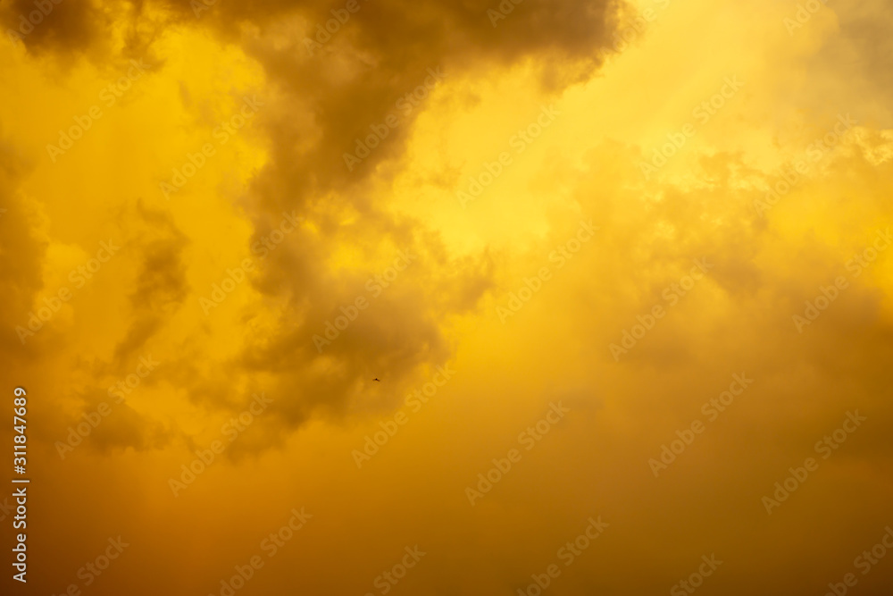 Orange color fluffy clouds on sunset time under dark blue sky