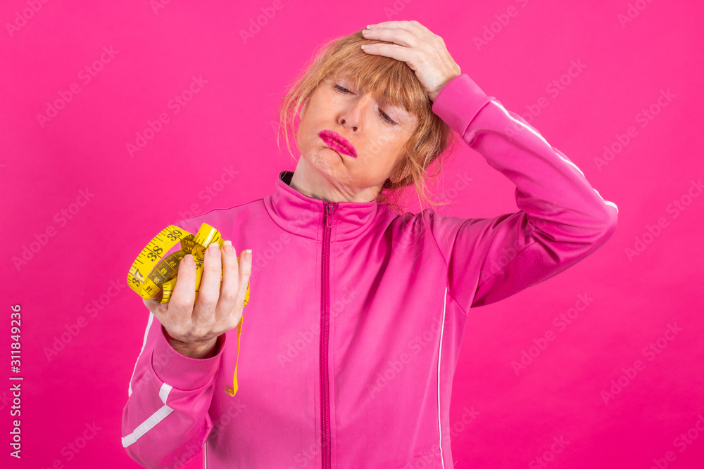 adult woman with stress and overwhelmed with sportswear and measuring tape isolated adult woman with stress and overwhelmed with sportswear and measuring tape isolated
