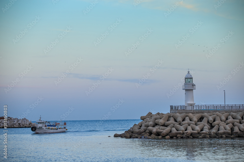 lighthouse. A lighthouse on the coast. A lighthouse on a breakwater. Lighthouse and Tetrapod.