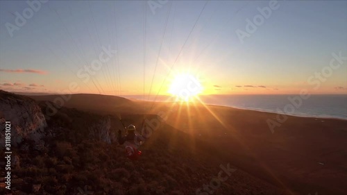 Beauty of free paragliding flying at sunset in ocean coast mountains in Morocco. Adrenaline adventure Slow motion photo
