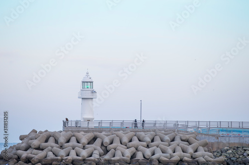 lighthouse. A lighthouse on the coast. A lighthouse on a breakwater. Lighthouse and Tetrapod.