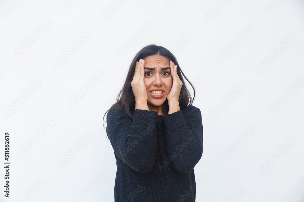 Shocked desperate woman holding head, realizing mistake. Beautiful young woman in casual sweater posing isolated over white background. Error or failure concept Shocked desperate woman holding head, realizing mistake. Beautiful young woman in casual sweater posing isolated over white background. Error or failure concept