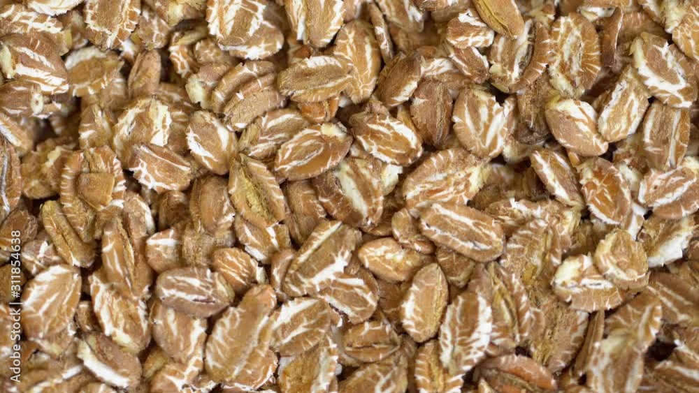 Dry wheat flakes grains background, close up rotation loopable 4k top view. Food background. Gastronomy concept, organic food. Macro rotation wheat flakes Dry wheat flakes grains background, close up rotation loopable 4k top view. Food background. Gastronomy concept, organic food. Macro rotation wheat flakes