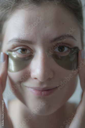 Moisturizing and tightening the skin under the eyes with the help of Korean cosmetics - beautiful patches for removing puffiness. Lifting procedure, cute caucasian girl