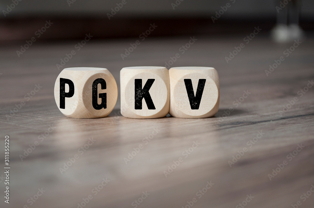 Cubes and dice with the acronyms PKV and GKV on wooden background