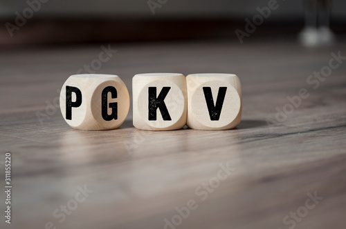 Cubes and dice with the acronyms PKV and GKV on wooden background