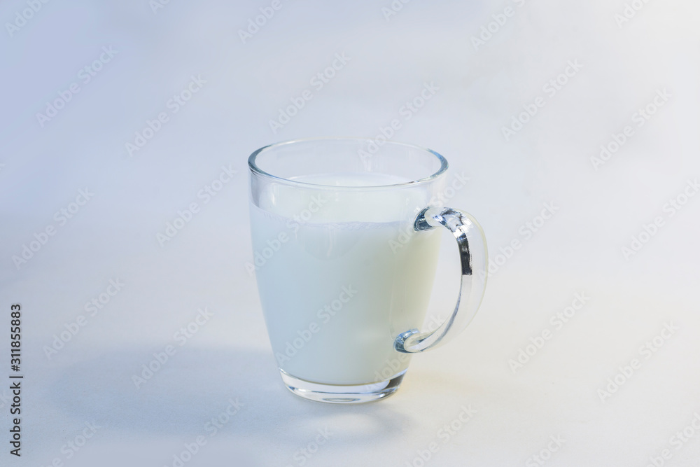 A cup of soy milk stands alone on a pale yellow background. A cup of soy milk stands alone on a pale yellow background.