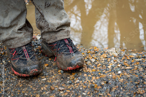 Muddy hiking shoes, isolated outdoors. photo