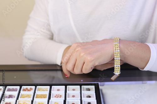Gemstone bracelet on seller hand while customer try on for buying