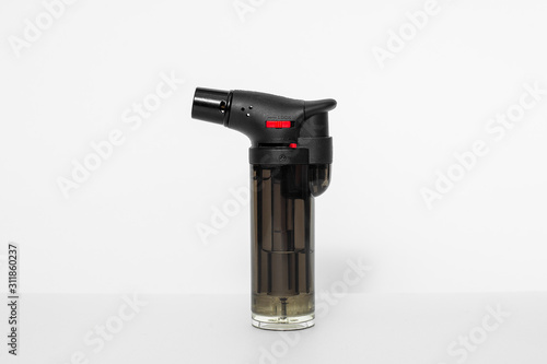 Culinary butane black plastic torch against a white background. gas burner for creme brulee isolated. photo