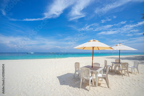 Empty tables and chairs with umbrella on the beach, near the sea. © Thanaphong