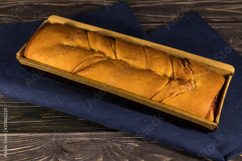Fresh homemade baking bun on blue towel wooden background