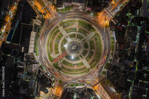 Road roundabout with car lots Wongwian Yai in Bangkok,Thailand. street large beautiful downtown at night light. Aerial view , Top view ,cityscape ,Rush hour traffic jam