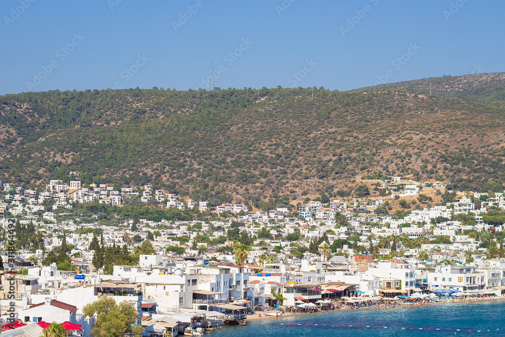Panoramic view from the walls of  Bodrum castle (also known as St Peter Castle) in Bodrum. Famous white cubic buildings, blue Aegean sea and green nature on the background, Mugla, Turkey.