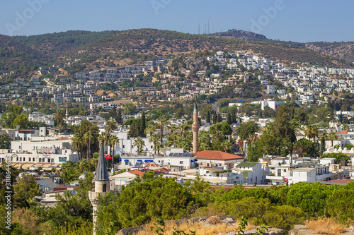 Panoramic view from the walls of Bodrum castle (also known as St Peter Castle) in Bodrum. Famous white cubic buildings, blue Aegean sea and green nature on the background, Mugla, Turkey.