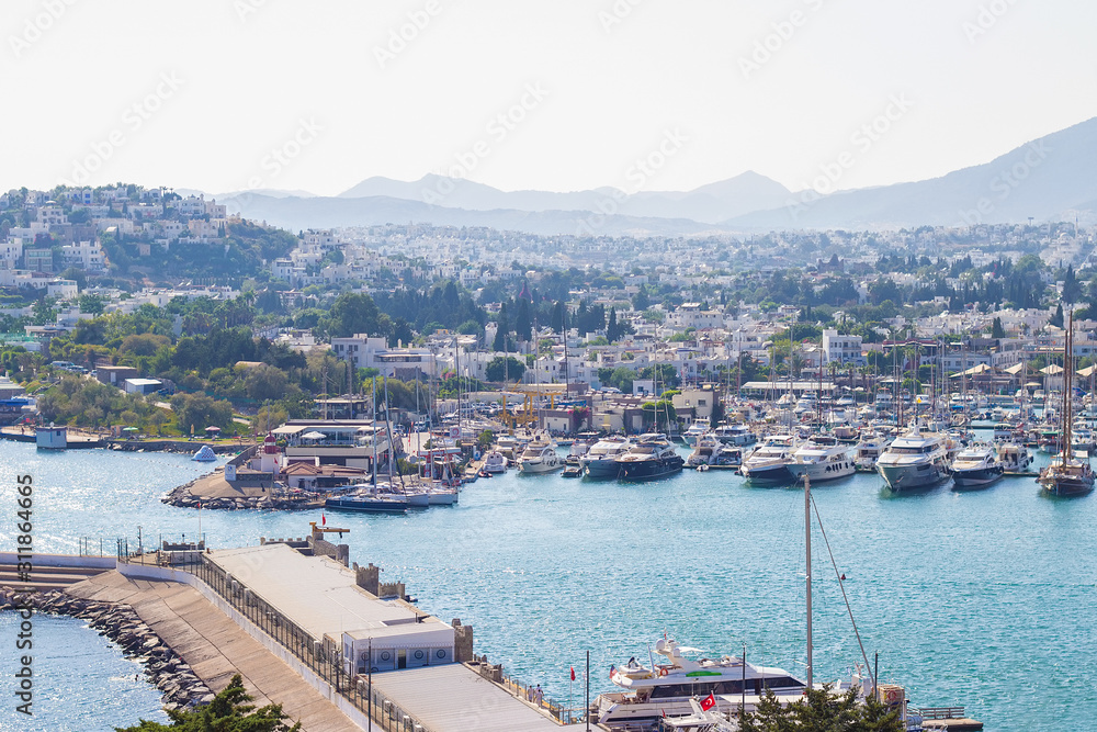 Panoramic view from the walls of famous St Peter Castle  in Bodrum, luxury white yachts, ships and sailing boats near the shores of blue Aegean sea, Mugla, Turkey. Travel concept. Turkish resort