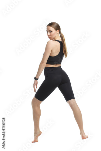 Slender athletic girl in sportswear isolated on white background.