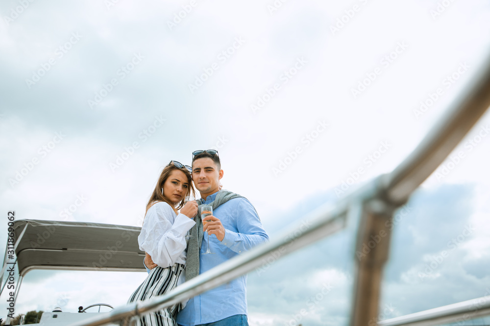 Newlyweds in love on sail boat with champagne - Happy exclusive alternative lifestyle concept. Couple celebrating with champagne on a boat having party with girlfriend on vacation. Newlyweds in love on sail boat with champagne - Happy exclusive alternative lifestyle concept. Couple celebrating with champagne on a boat having party with girlfriend on vacation.