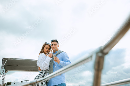 Newlyweds in love on sail boat with champagne - Happy exclusive alternative lifestyle concept. Couple celebrating with champagne on a boat having party with girlfriend on vacation. © Air_Lady