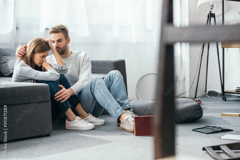 handsome man calming down sad woman in robbed apartment handsome man calming down sad woman in robbed apartment