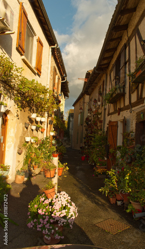 Fototapeta Naklejka Na Ścianę i Meble -  Perspective pour cette magnifique rue fleurie de Casseneuil dans le département du Lot et Garonne