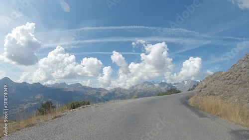 Vehicle point of view shot while driving on the road climbing to the mountain pass Granon in Massif des Cerces in the French Alps. photo