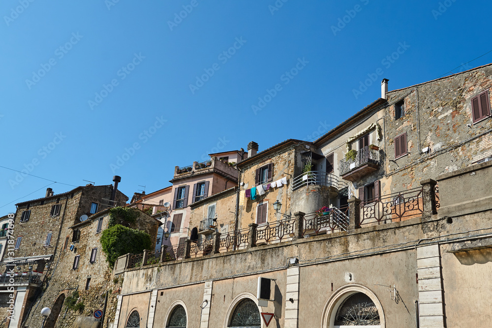 Street with stone, historic buildings in the city of Manciano in Italy.