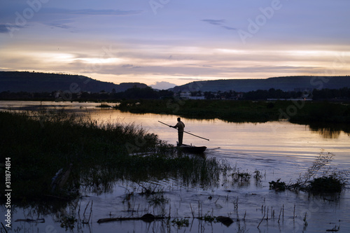 Valokuva Malian Fisherman Poling His Boat Along The niger Riverside In The late Evening