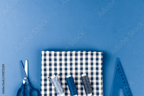 Tayloring accessories on classic blue background, top view photo