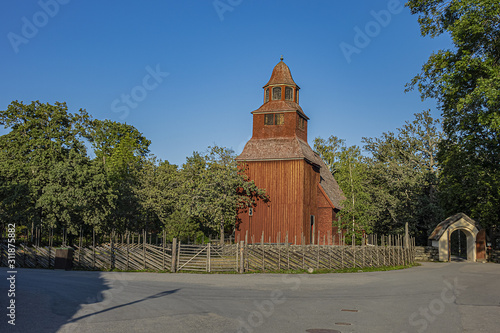 Traditional architecture of old Swedish building in Skansen open air museum at Djurgarden island, historic recreational area. XVIII century wooden Seglora church. Stockholm, Sweden. photo