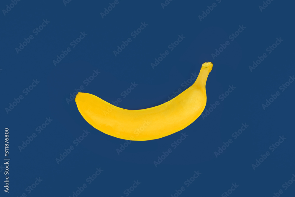 toy yellow plastic banana on blue colored background toy yellow plastic banana on blue colored background