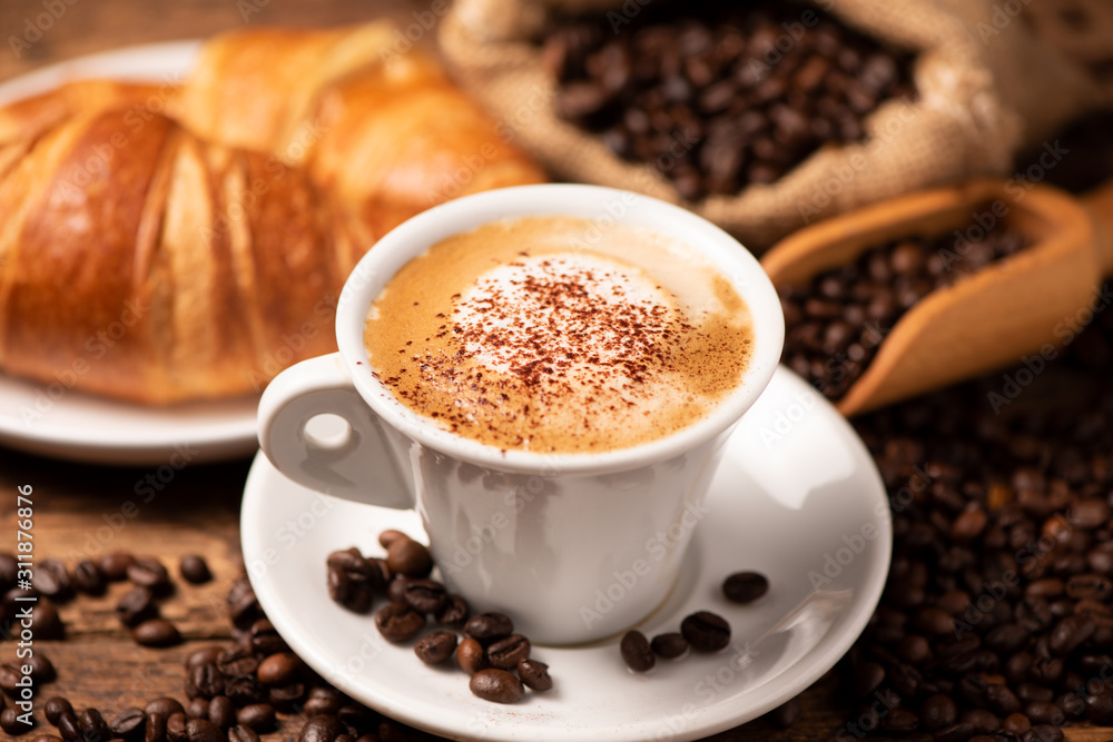 A cup of cappuccino with coffee bean as background. A cup of cappuccino with coffee bean as background.