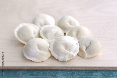 Dough product: dumplings in flour on wood board before putting in cooking water