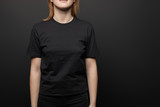 cropped view of woman in blank basic black t-shirt on black background